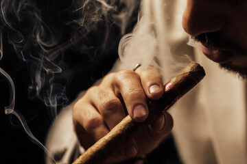 Man smoking a cigar on a wooden bar table
