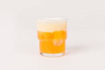 Orange vitamin C effervescent tablet dropped and dissolve in glass of water with bubbles isolated on white background
