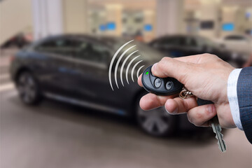 Men's hand presses on the remote control car alarm systems.