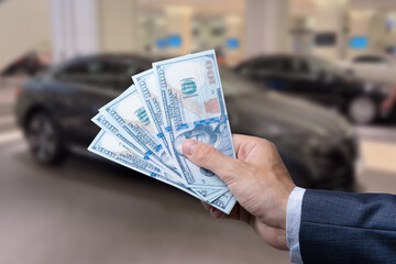 Man with 100 dollar banknotes money near car. Buy or rent a new auto. Finance concept.