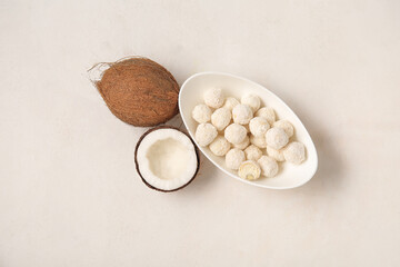 Bowl with white chocolate candies and coconuts on light table