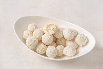 Bowl with delicious coconut candies on light table