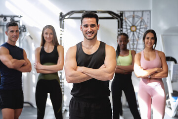 Fototapeta premium group of fitness and multi-ethnic people posing for the camera with their arms crossed at the gym