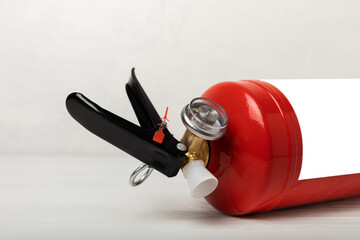 Obraz premium Fire extinguisher on a white texture background. Fire protection, home fire extinguisher. home security concept. Place for text. Copy space.banner