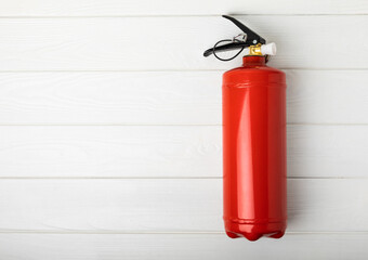 Obraz premium Fire extinguisher on a white texture background. Fire protection, home fire extinguisher. home security concept. Place for text. Copy space.banner