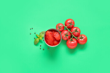 Canned, fresh tomatoes and spices on green background