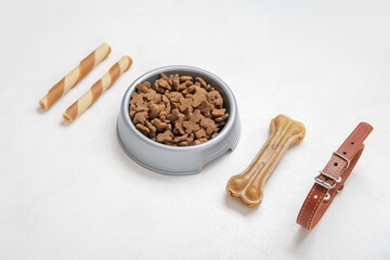 Different pet food and collar on light background