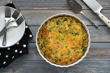 A baked ham, cheese & spinach quiche being served. 