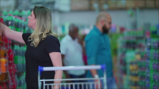 Female Consumer With Cart Navigating Supermarket Shelves, Shoppers In Grocery Store Aisle Scouring For Products