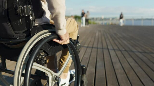 Riding forward, dynamic. Detail of back of disabled man riding outdoors 