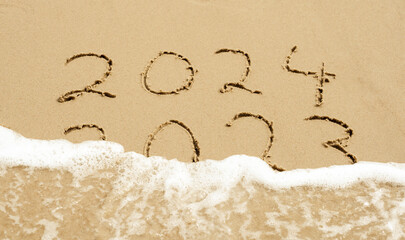 Symbol for the new year 2024. Wave is washing away the inscription 2023.