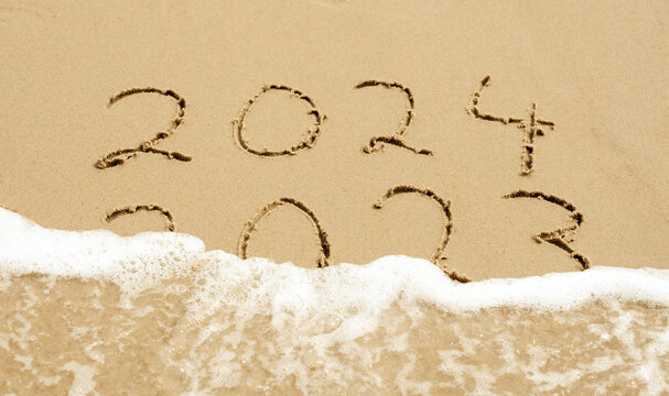 Symbol for the new year 2024. Wave is washing away the inscription 2023.