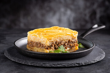 Piece of shepherd's pie on dark plate.