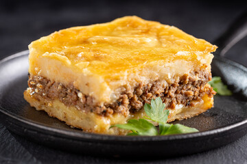 Piece of shepherd's pie on dark plate.