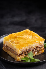 Piece of shepherd's pie on dark plate.