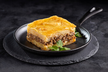 Piece of shepherd's pie on dark plate.