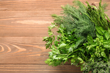 Assortment of fresh herbs on wooden background