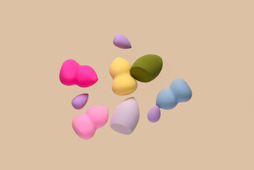 Flying different makeup sponges on beige background