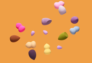 Flying different makeup sponges on orange background