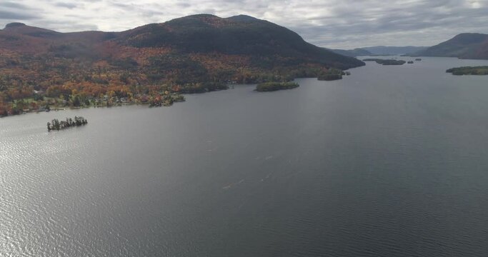 Drone flight over Lake George in autumn with colourful forests, near Sabbath point, Bolton, New York, USA, North America