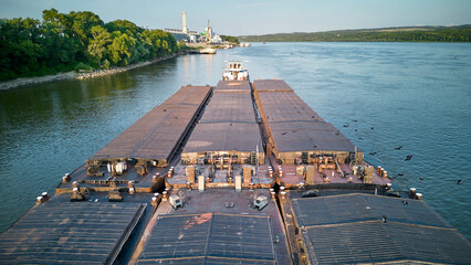 Aerial view of tugboat pushing barges up a river