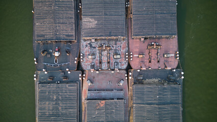 Aerial view of tugboat pushing barges up a river