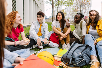 Student friendship concept with multiracial classmate friends sitting together on the grass at...