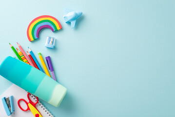 All you need for a drawing lesson, from top view: vibrant stationery, pencil case, pens, album, plasticine, stapler, scissors, sharpener, eraser. Pastel blue background, text or ads welcome