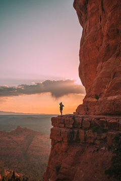  Young hiker woman on the edge of a cliff at Cathedral Rock in Sedona, Arizona. View from Scenic Cathedral Rock in Sedona with blue sky in Arizona