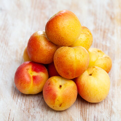 Naklejka na ściany i meble Image of ripe juicy apricots on wooden table, nobody