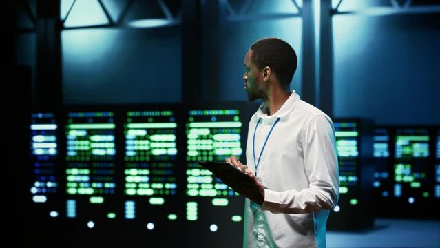 IT programmer in server hub using tablet to find firewall misconfigurations affecting mainframes performance and connectivity, leading to slow data transfer rates and poor client communication