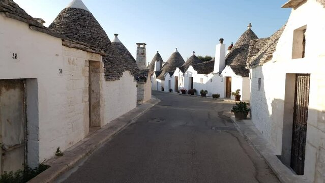 Alberobello Italy - traditional trulli houses with conical stone roofs. Famous landmark, travel destination and tourist attraction near Bari in Puglia, Europe. Street with ancient architecture.