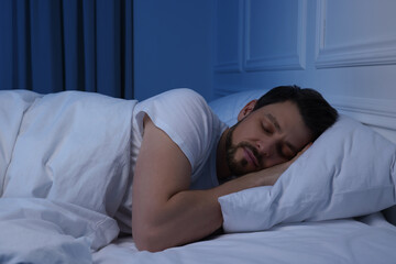 Handsome man sleeping in bed at night