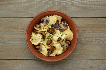 Delicious ravioli with mushrooms on wooden table, top view
