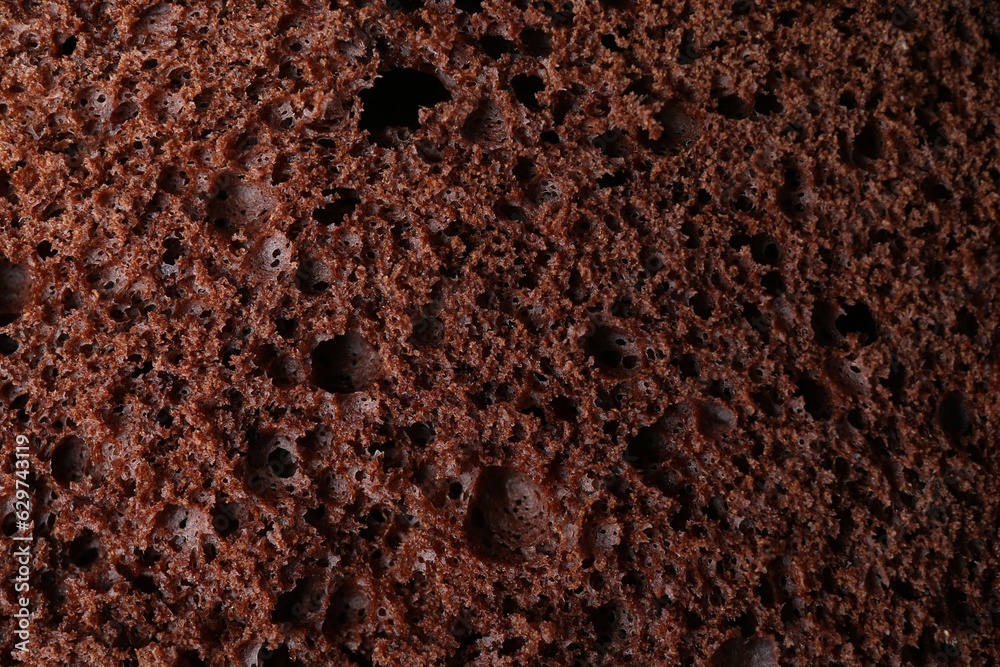 Sticker tasty chocolate sponge cake as background, closeup