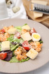 Delicious Caesar salad with shrimps on white table, closeup