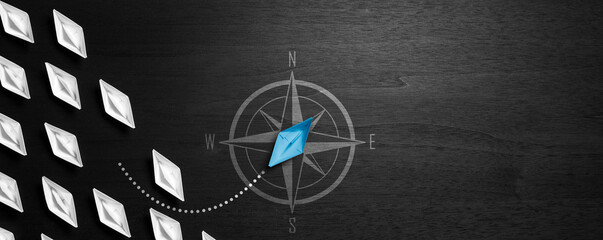 Blue Paper Boat Leaving Mainstream And Changing Direction With Compass On Modern Black Wooden Table  - Entrepreneur Concept	


