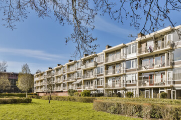 an apartment complex with trees and bushes in the foreground area on a bright sunny day, as seen from below