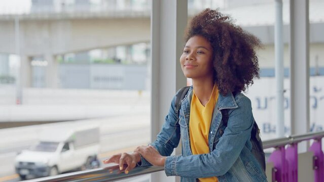 Attractive african teenager girl standing in the city, looking at around