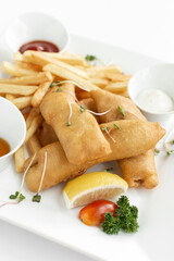 british traditional fish and chips meal in restaurant on white plate - 629752195
