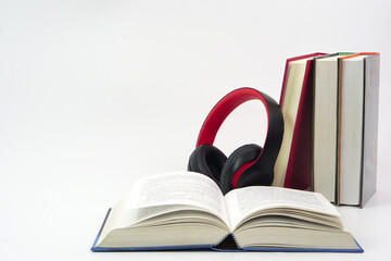 The headphones placed on top of the lined up books. Knowledge, learning and education concept.