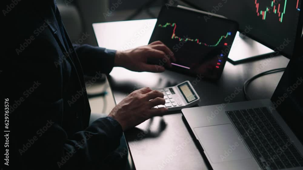 Fototapete Back view of stock market broker in analyzing data and graphs on multiple computer screens while sitting in modern office.