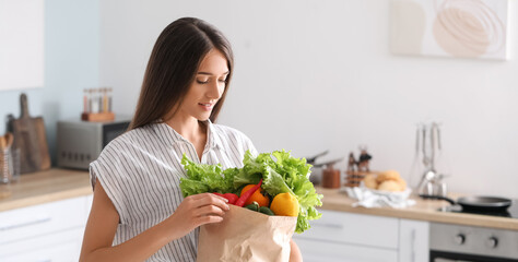 Young woman with fresh products from market at home