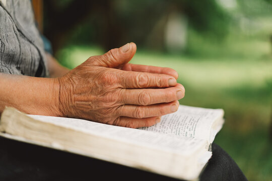 Bible, reading book or old woman praying for hope, help or support in Christianity religion or holy faith. Prayer or senior person studying or worshipping God in spiritual literature at outdoors