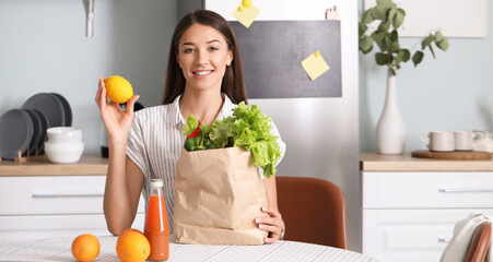 Obraz premium Young woman with fresh products from market at home
