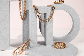 Decorative podiums with beautiful jewelry on white background