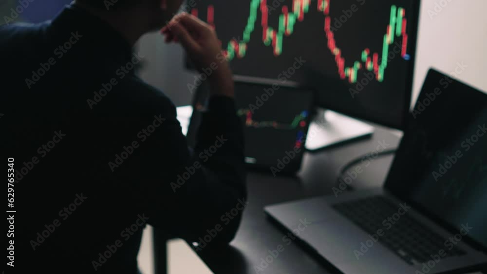Poster Back view of stock market broker in analyzing data and graphs on multiple computer screens while sitting in modern office.
