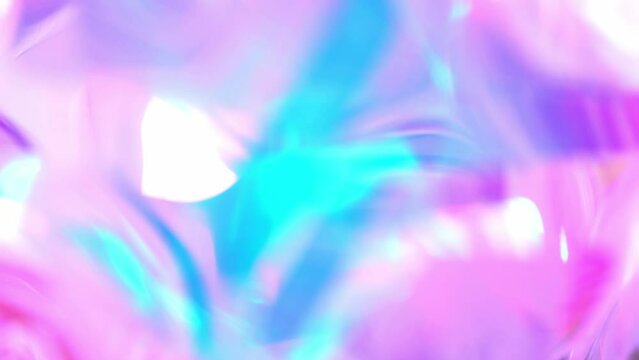 A holographic rainbow iridescent unicorn pastel purple pink teal blue colors abstract background. Lens light leaks flash