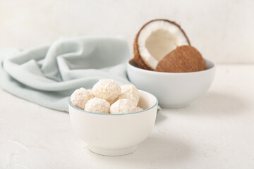 White chocolate candies with coconut topping in bowl on light table