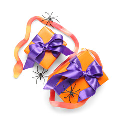 Tasty candy in shape of snake, spiders and gift boxes for Halloween on white background